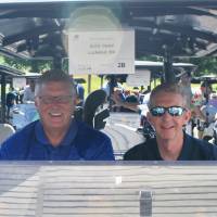 2 men in a designated golf cart